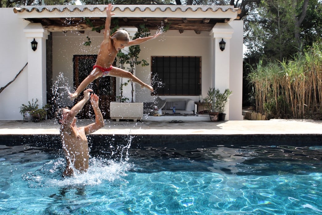 Family playing in a villa pool abroad