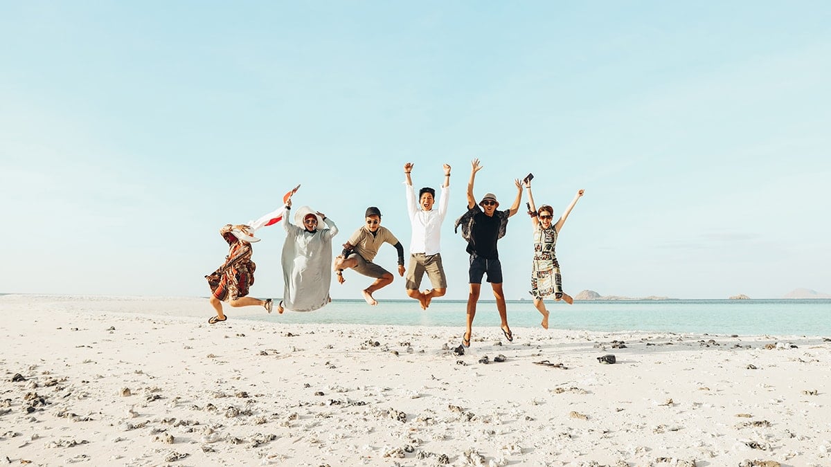 Expats on a beach jumping for joy