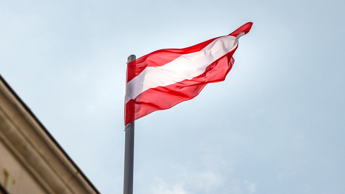 Austria Flag flying above a building with blue sky